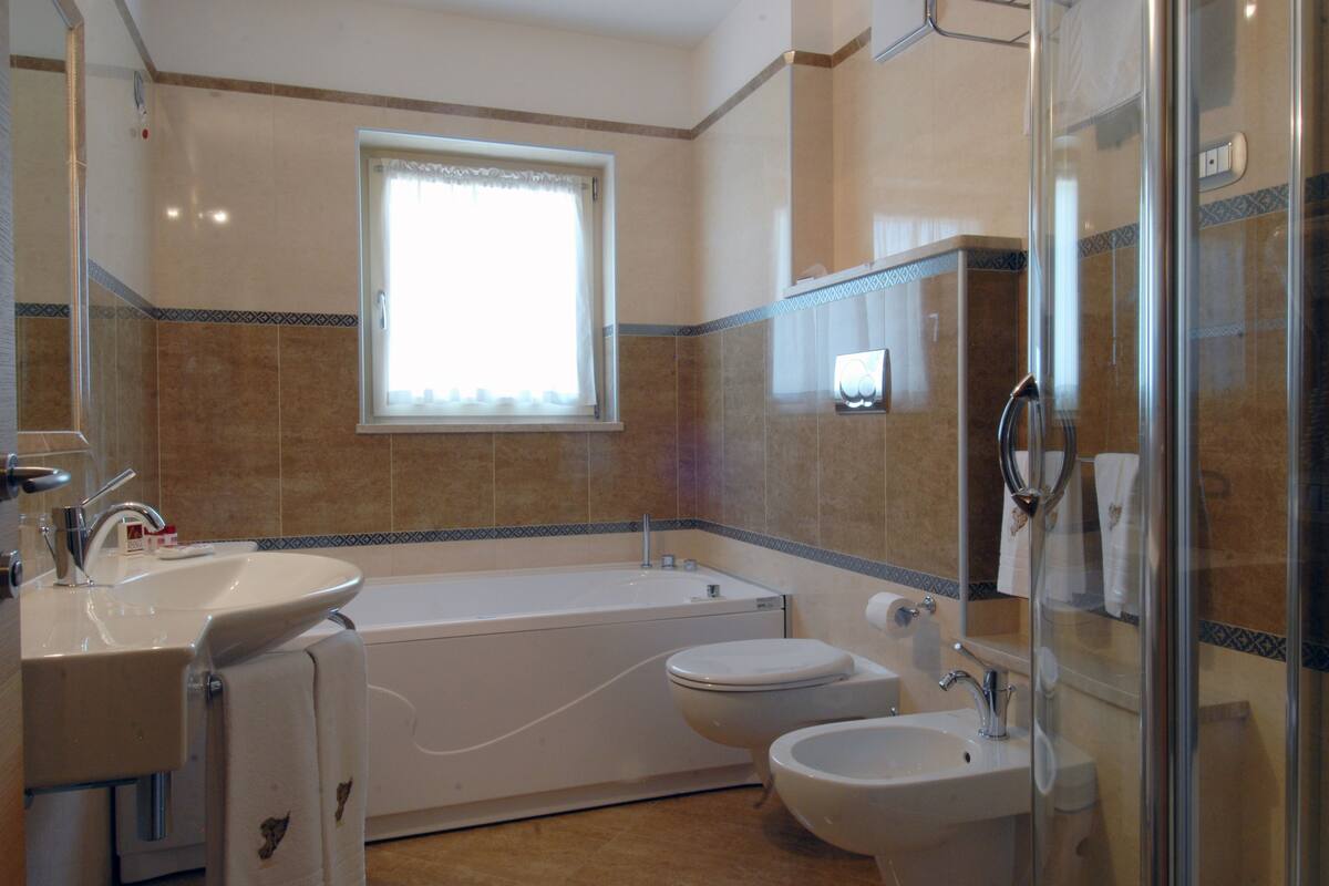 junior suite | bathroom | combined shower/bathtub, hydromassage showerhead, designer toiletries