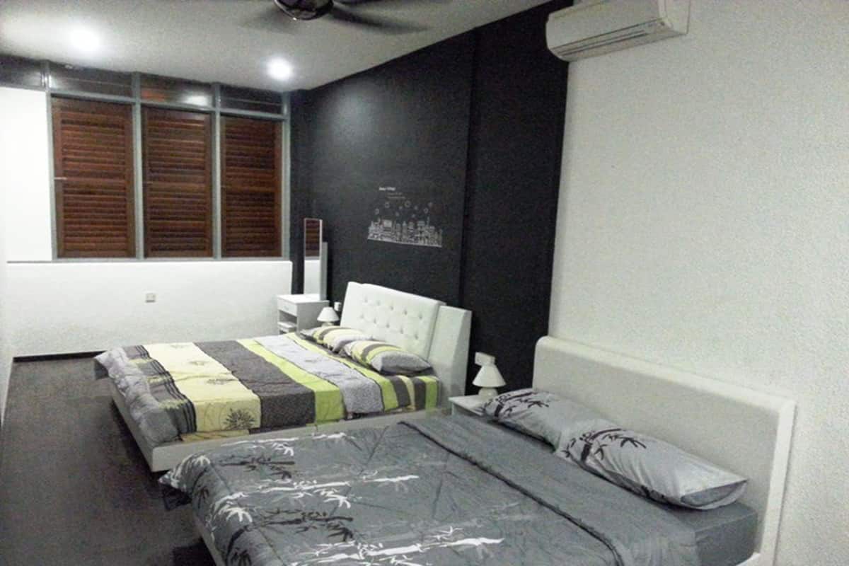 A bedroom with a large bed, a smaller bed, a nightstand, a lamp, and a wall-mounted air conditioner.