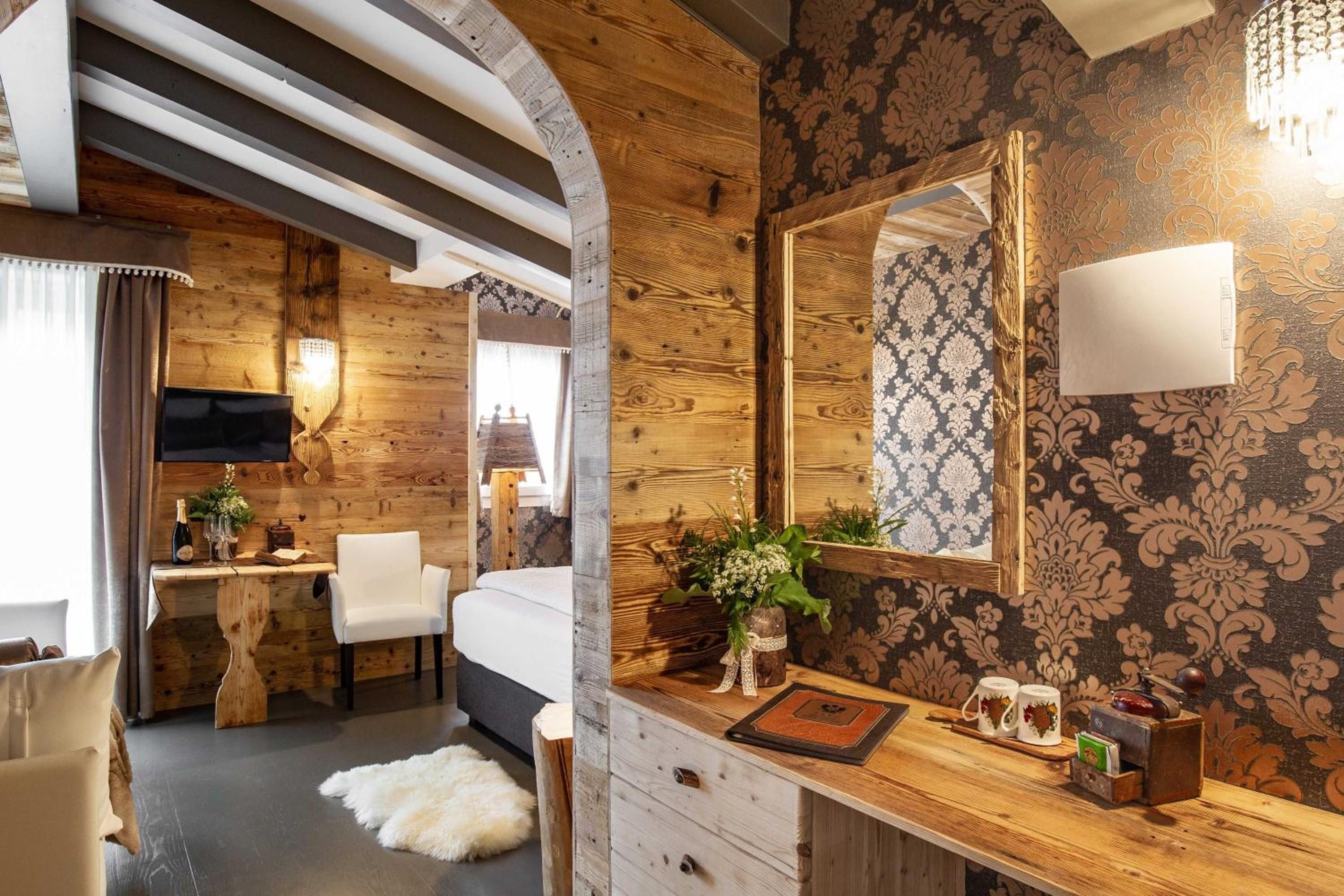 Ein Zimmer mit einem Bett, einem Schreibtisch, einem Stuhl, einem Spiegel und einer kleinen Pflanze.