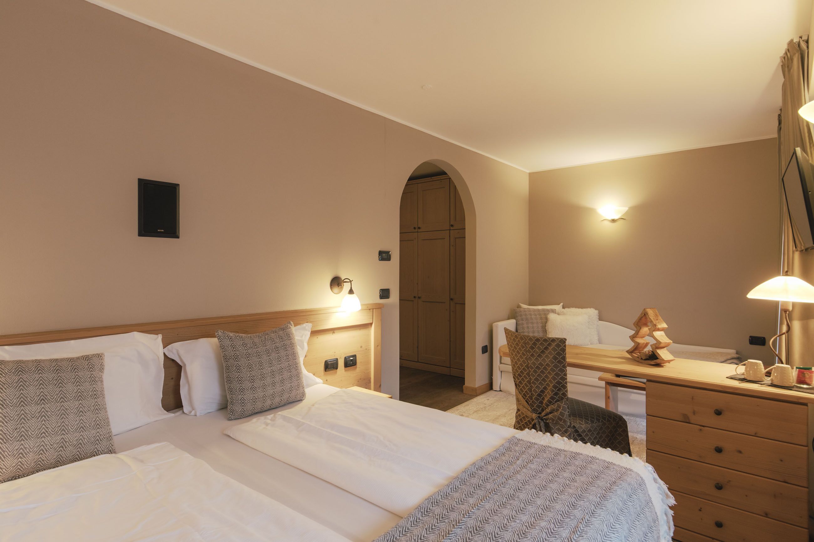 Ein Hotelzimmer mit einem Bett, einem Schreibtisch, einem Stuhl, einem Kleiderschrank und einer Lampe.