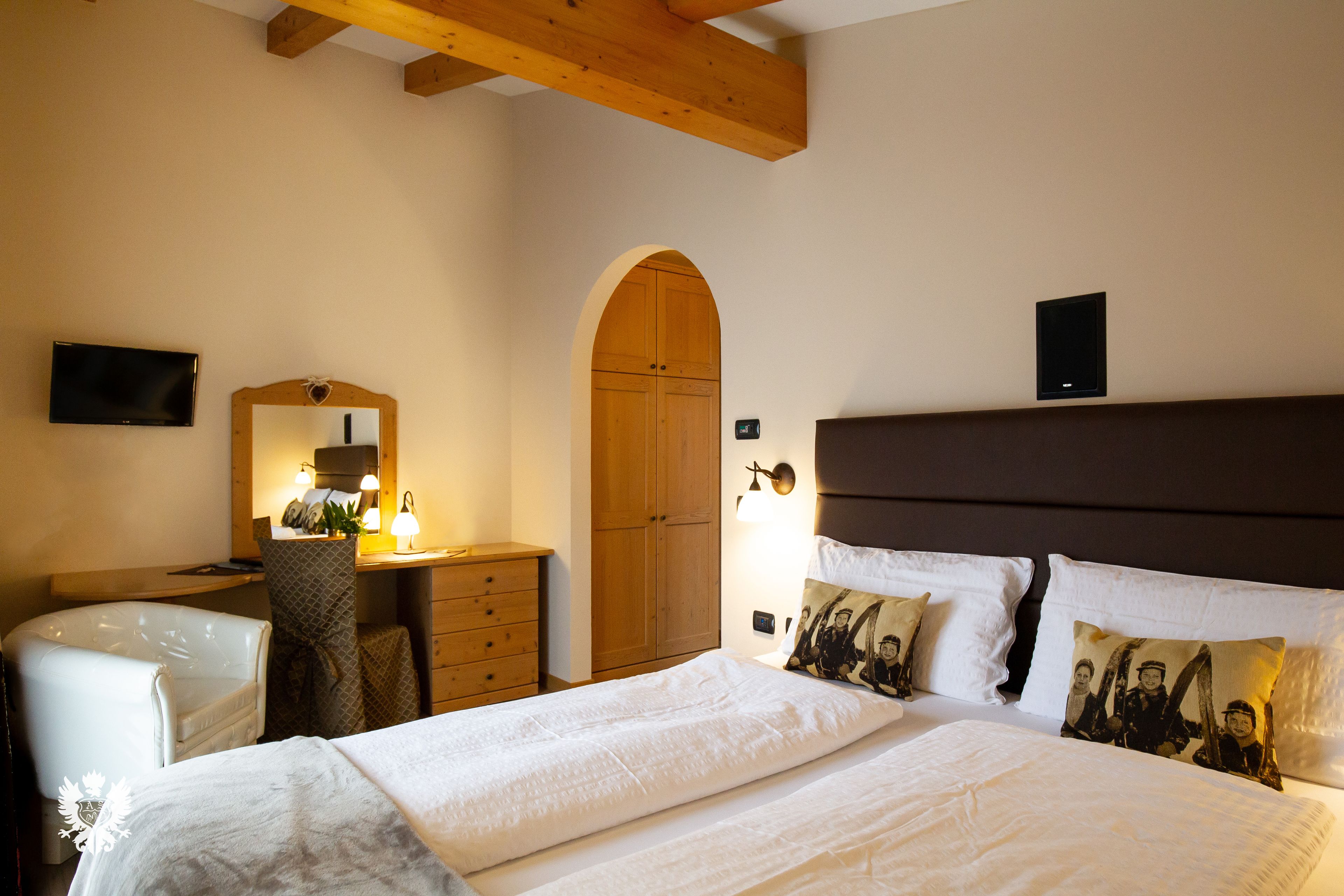 Ein Schlafzimmer mit Bett, Schreibtisch, Stuhl, Spiegel und Kleiderschrank.