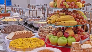 A buffet with various food items including fruits, pastries, and desserts. - Atobá Praia Hotel (Balneário Camboriú)
