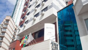 A hotel with a modern facade, multiple balconies, and a prominent glass entrance. - Atobá Praia Hotel (Balneário Camboriú)