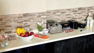 Una encimera de cocina con frutero, tostadora y varios electrodomésticos.