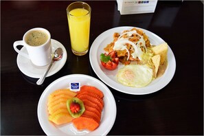 A breakfast plate with scrambled eggs, a fried egg, and a slice of toast, accompanied by a glass of orange juice and a cup of coffee. - Sleep Inn Culiacan (Culiacán)