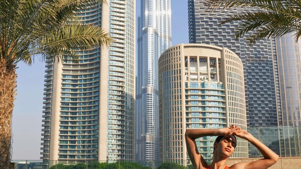 A swimming pool with a person in a red swimsuit, surrounded by tall modern buildings. - Sofitel Dubai Downtown (Dubai)