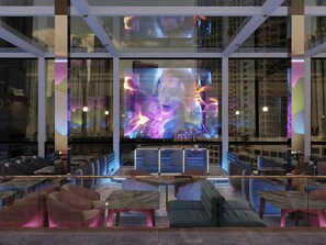 Un intérieur moderne doté d’un grand écran numérique, d’espaces de détente et d’une façade en verre.