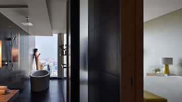 Een moderne badkamer met een bad, douche en een grote spiegel.