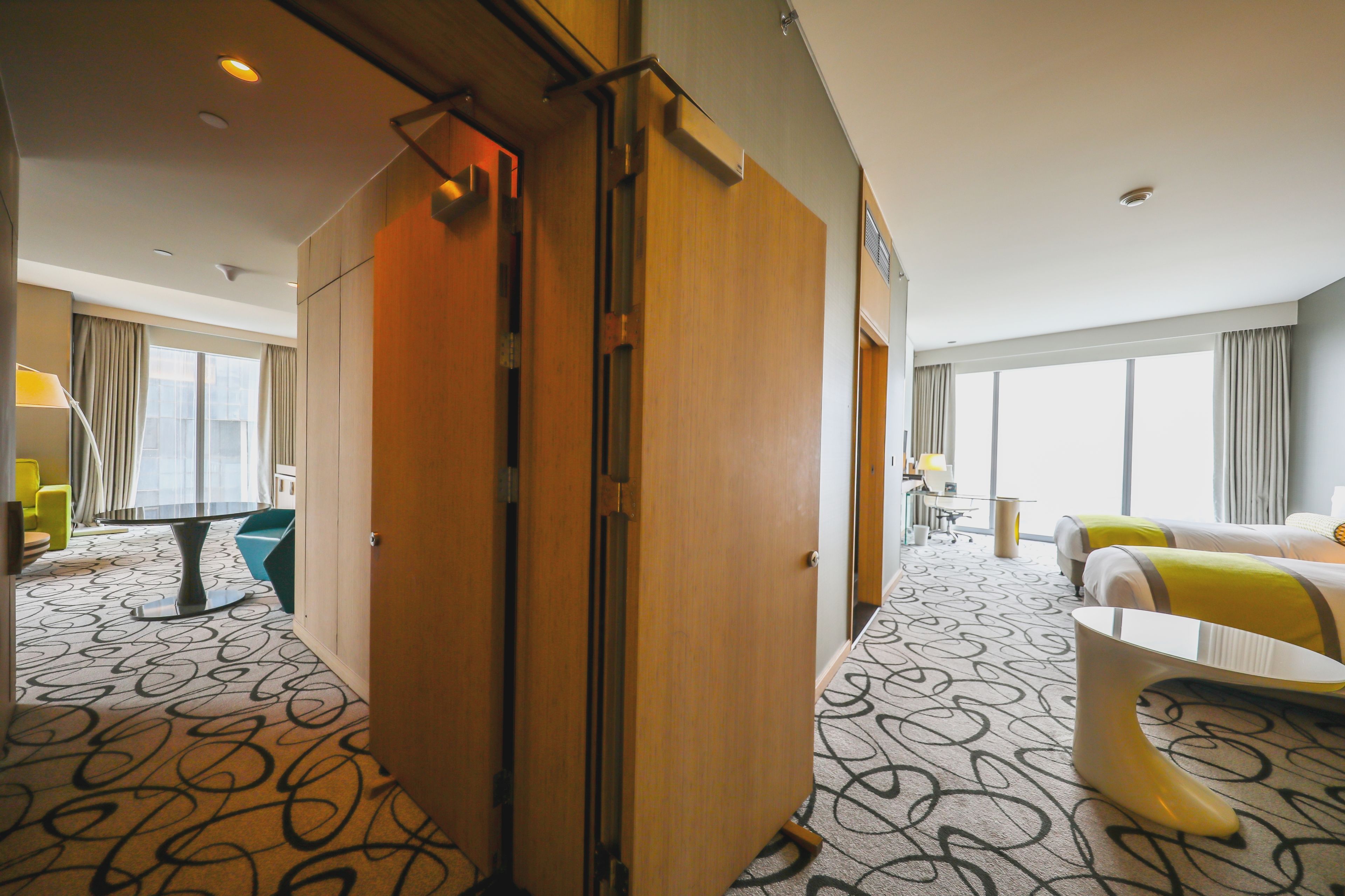 A hotel room with a large bed, a desk, and a view of the city.