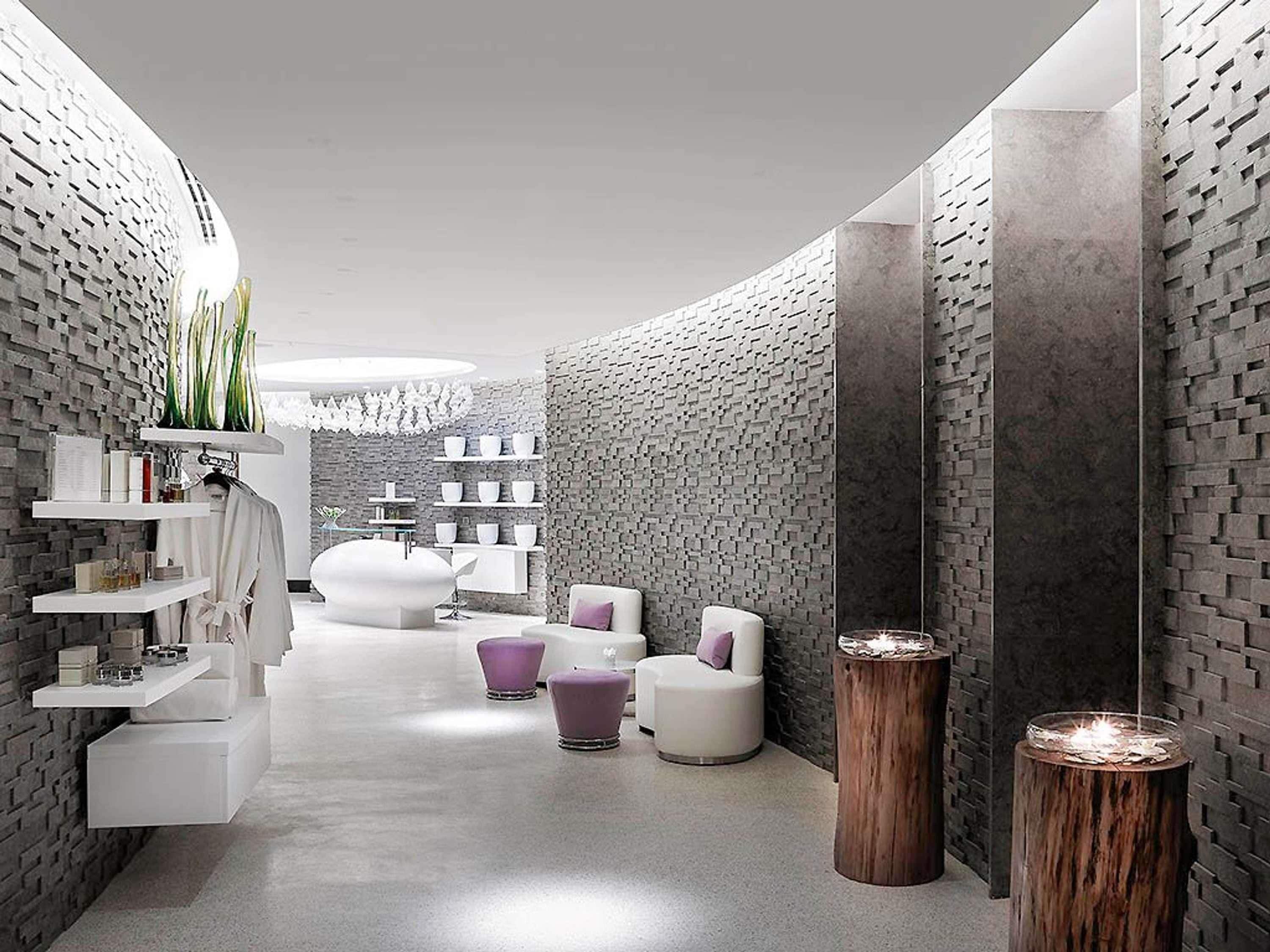 A modern bathroom with a brick wall design, white shelves, and a central seating area with a round table and chairs.