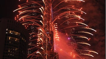 A nighttime view of a tall building with a complex structure and multiple floors.