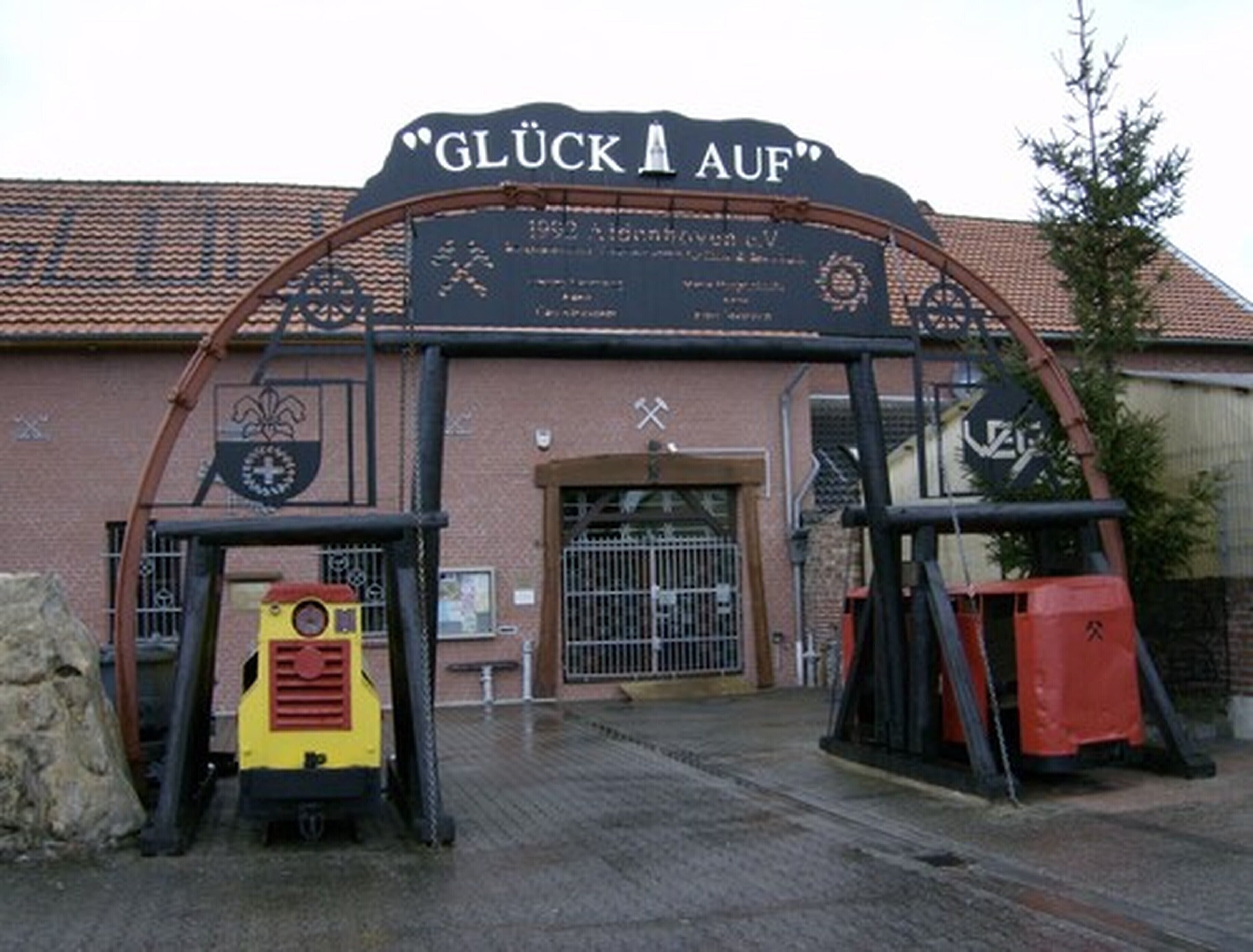 A building entrance with a sign reading "GLÜCK AUF" and a logo.