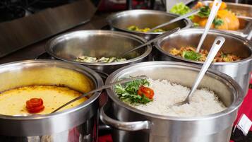 A buffet with various dishes including rice, a creamy soup, and a vegetable dish.
