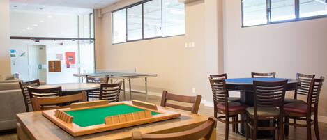 A room with a pool table, multiple chairs, and a sofa.