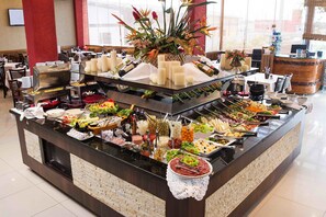 A buffet setup with various food items and a wine selection.