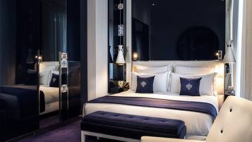 Un dormitorio moderno con una cama grande, una mesita de noche, un espejo y una silla.