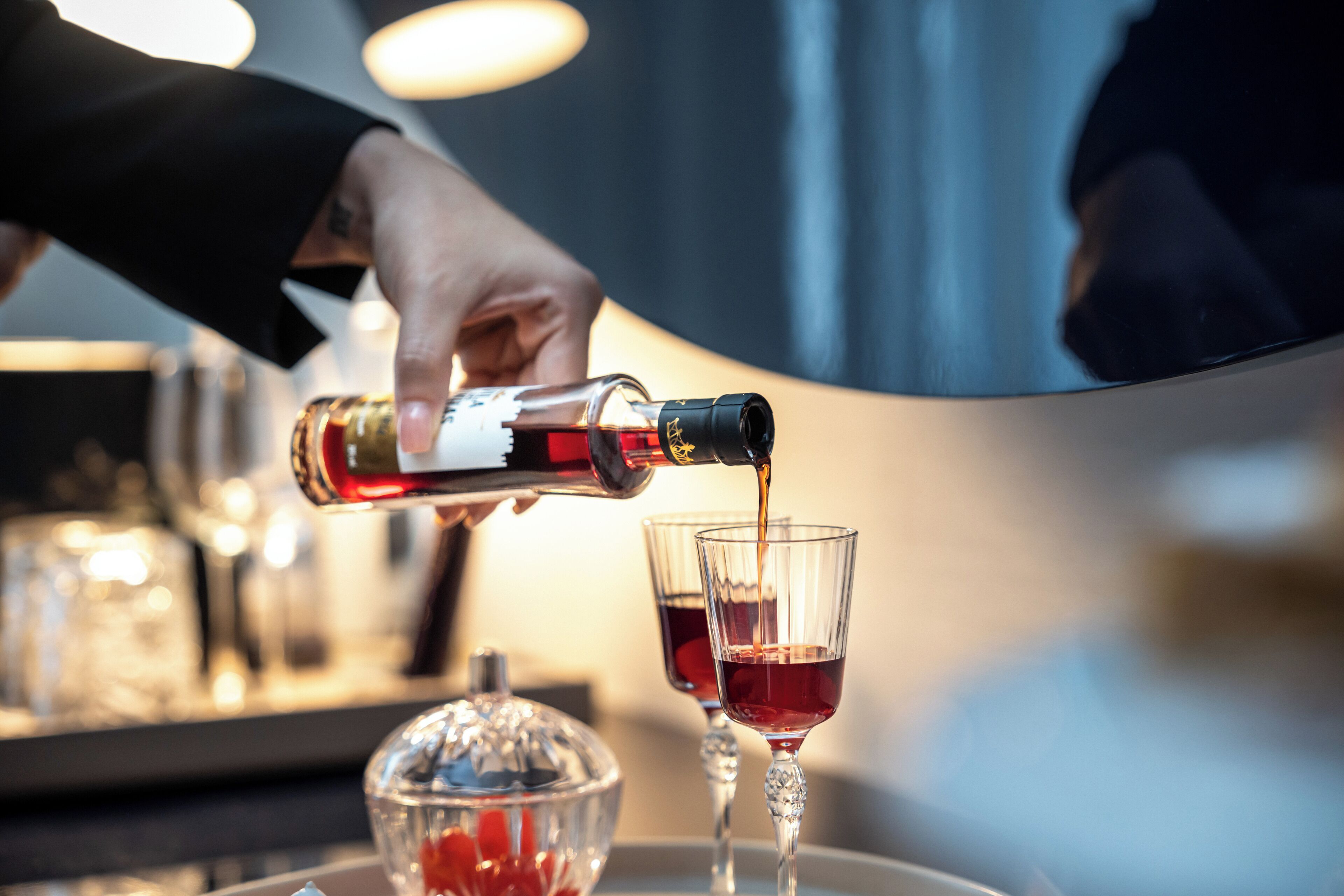 Une main versant une boisson dans un verre.