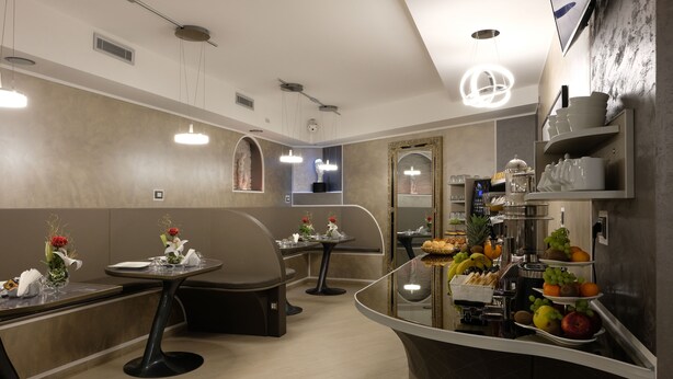 A modern restaurant with booths, round tables, and a central counter with fruit and bread. - LeNotti Verona (Verona)