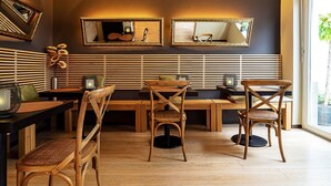 Un espace repas moderne, avec des meubles en bois, un grand miroir et une vue sur la verdure environnante.