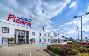 A hotel named 'Hotel Piccaro' with a modern facade, a covered entrance, and a parking area with blue markings. - Hotel Picaro Żarska Wieś Południe (Zgorzelec)
