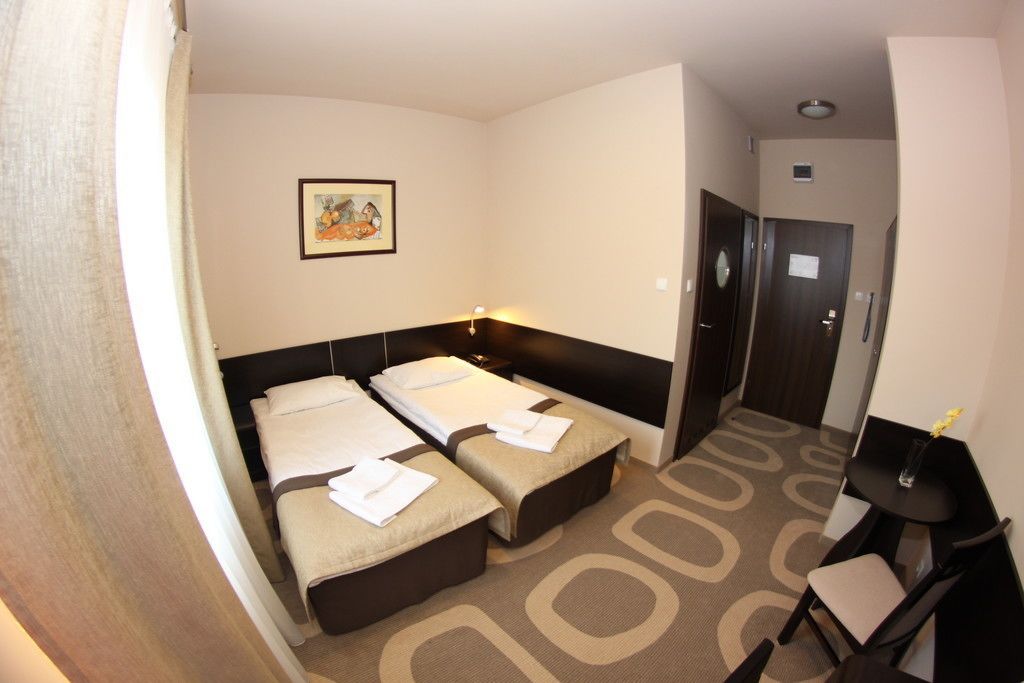 Habitación de hotel con dos camas, un escritorio y una silla.