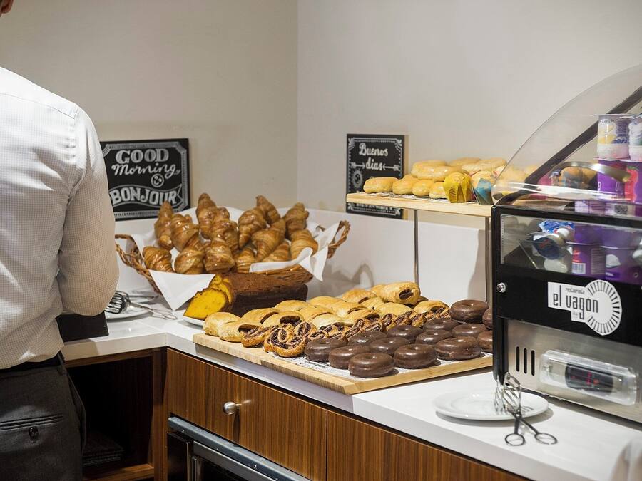 A breakfast buffet with various pastries and a coffee machine.