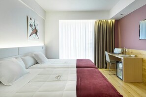 A hotel room with two beds, a desk, a chair, and a minibar. - Hotel Sercotel Ciudad de Miranda (Miranda de Ebro)