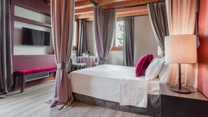 Une chambre à coucher avec un lit, une table de chevet, une lampe et des rideaux.