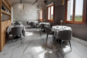A restaurant with marble flooring, round tables, and chairs.