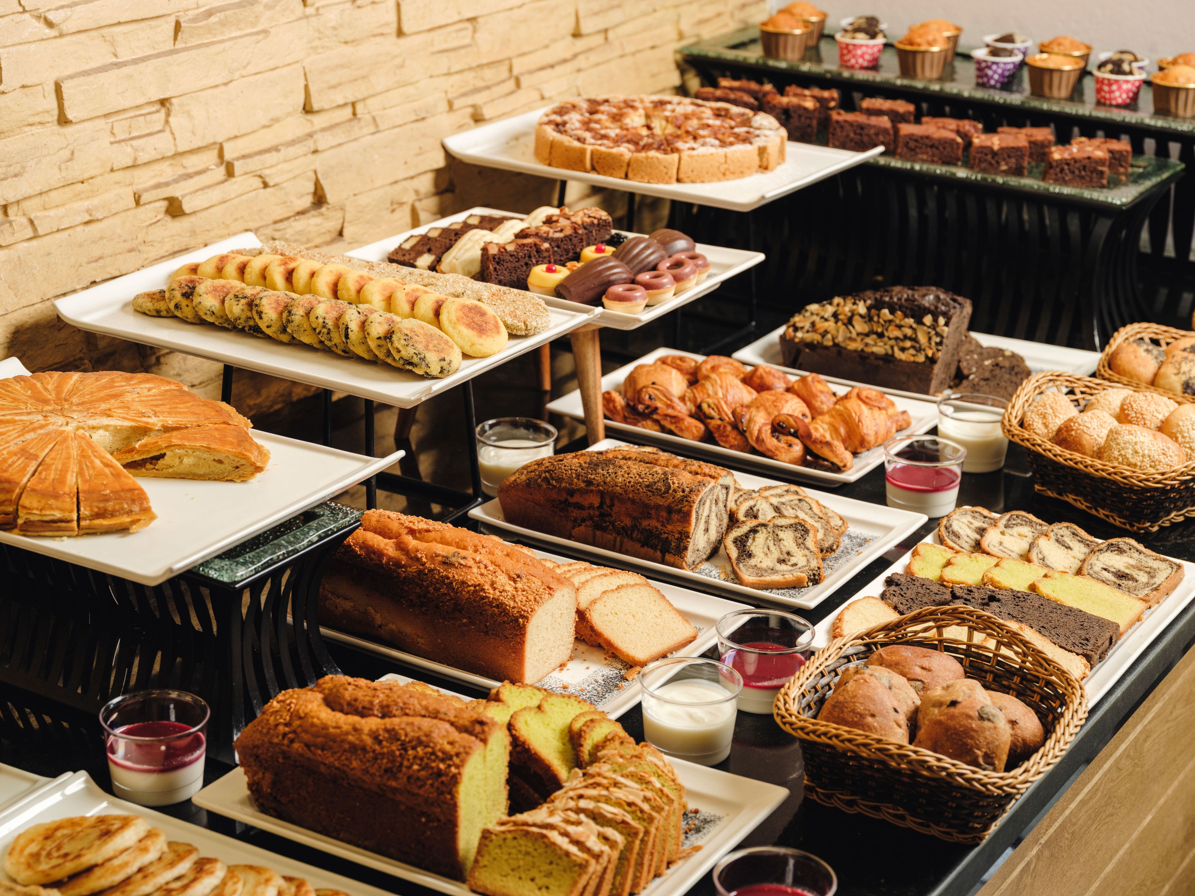 A buffet with various baked goods and pastries.