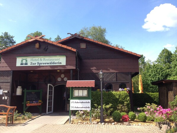 Un edificio de madera tradicional con un letrero que indica que es un hotel y restaurante llamado "Zur Spreewälderin".