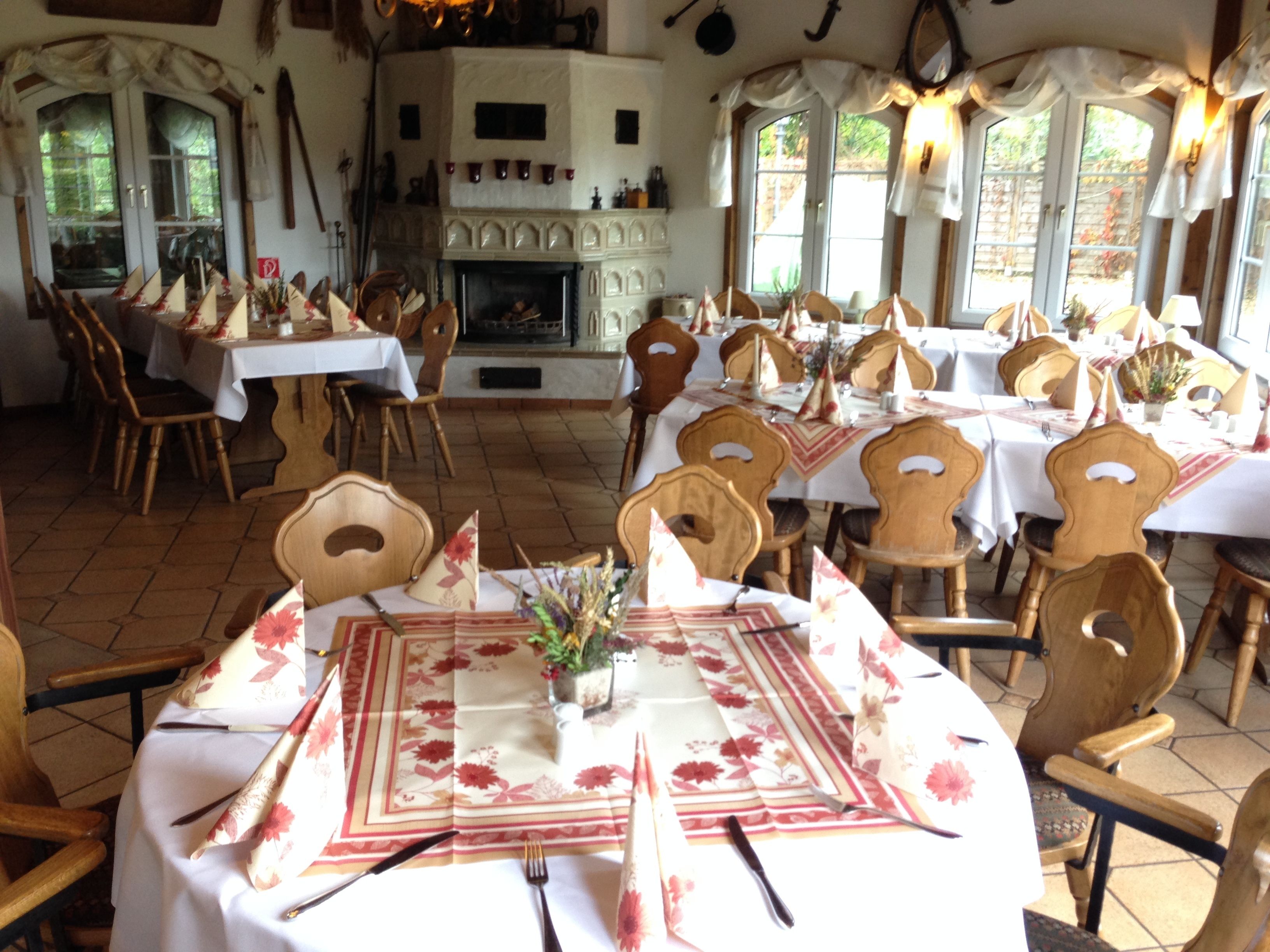 Un espace repas avec des tables rondes, des chaises en bois et une cheminée.