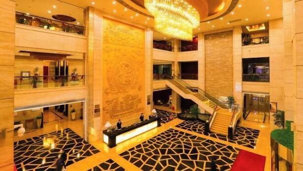 A spacious lobby with a grand chandelier, multiple floors, and a central staircase. - Xiongsen Holiday Villa (Chenzhou)