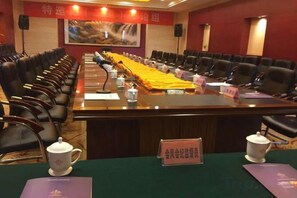 A conference room with a long table, chairs, and nameplates. - Xiongsen Holiday Villa (Chenzhou)