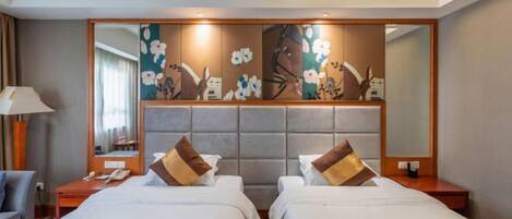 A hotel room with two beds, a large mirror, and a decorative wall panel.