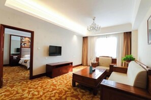 A hotel room with a bed, a TV, a wooden coffee table, a sofa, a chandelier, and a large window with curtains. - Xiongsen Holiday Villa (Chenzhou)