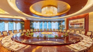A conference room with a round table, chairs, and a chandelier. - Xiongsen Holiday Villa (Chenzhou)