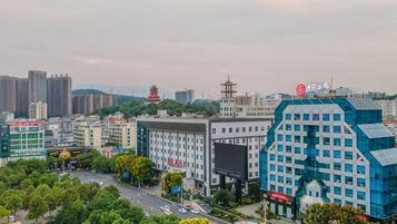 A cityscape with modern buildings, a pagoda, and a large blue structure with a sign.