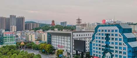 A cityscape with modern buildings, a pagoda, and a large blue structure with a sign.