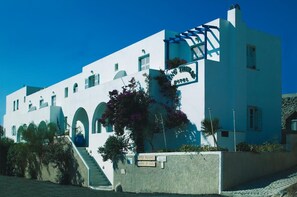 A white building with a sign that reads "Hotel". - King Thiras (Santorini)