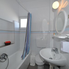 A bathroom with a bathtub, toilet, and sink. - King Thiras (Santorini)