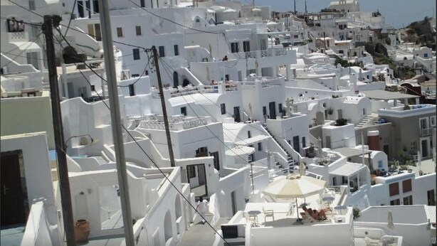 A densely packed white building area with narrow streets and staircases connecting different levels. - King Thiras (Santorini)