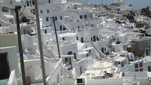 A densely packed white building area with narrow streets and staircases connecting different levels. - King Thiras (Santorini)