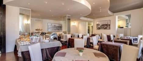 Un restaurante con mesas redondas, sillas blancas y un techo curvo.