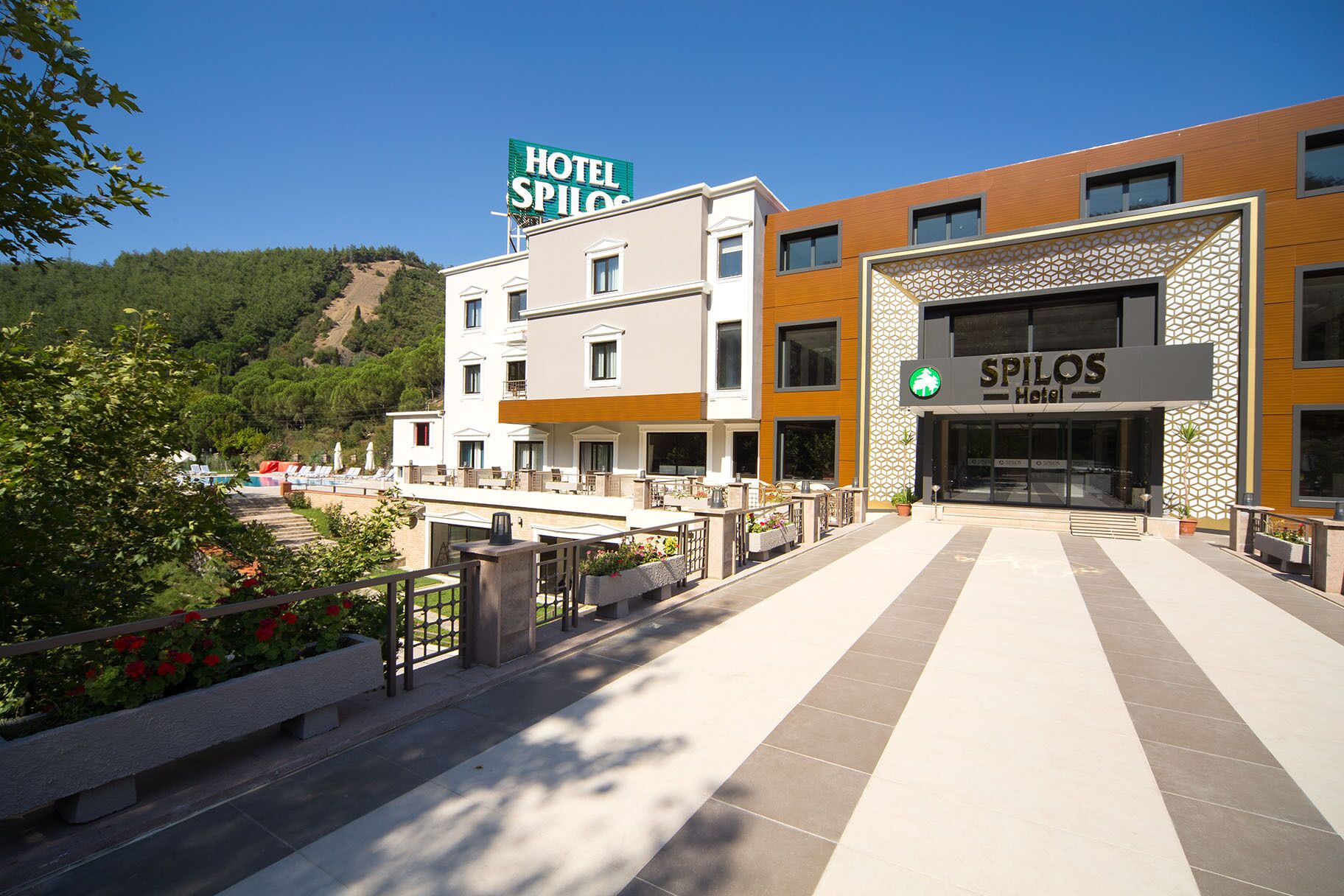 Un hôtel doté d’une enseigne bien visible, d’un espace piscine et d’une façade moderne.