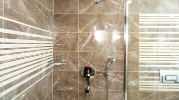 Ein Badezimmer mit Dusche, Toilette und Bidet.