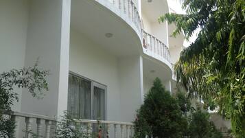 A white building with a curved balcony and a window.