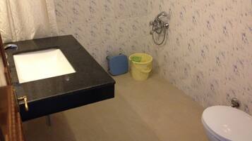 Un baño con lavamanos, inodoro y ducha.
