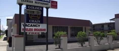 Ein Gebäude mit Schildern für River Park Motor Inn, ein Restaurant mit Lizenz und Kennzeichnung freier Zimmer.