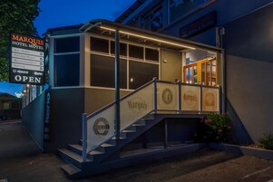 A hotel named Marqus with a signboard listing amenities like a bar, bistro, function room, accommodation, and gaming.